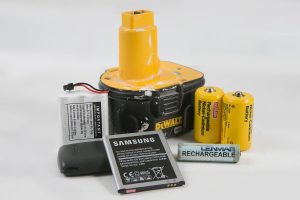 Rechargeable and lithium batteries from power tools and electronics on white background
